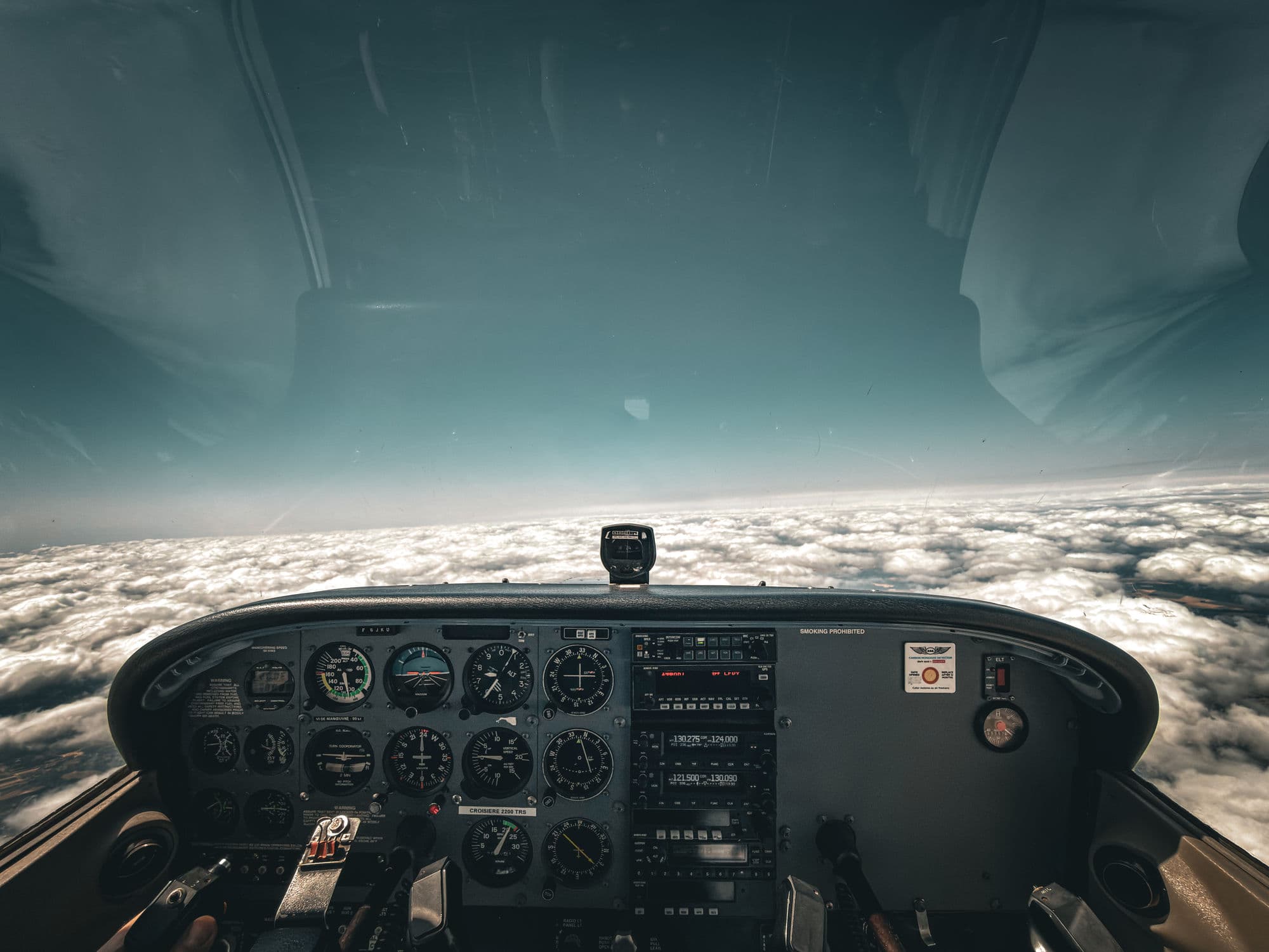 Poste de pilotage du Cessna 172R F-GJKU en vol au-dessus d'une couche de nuages