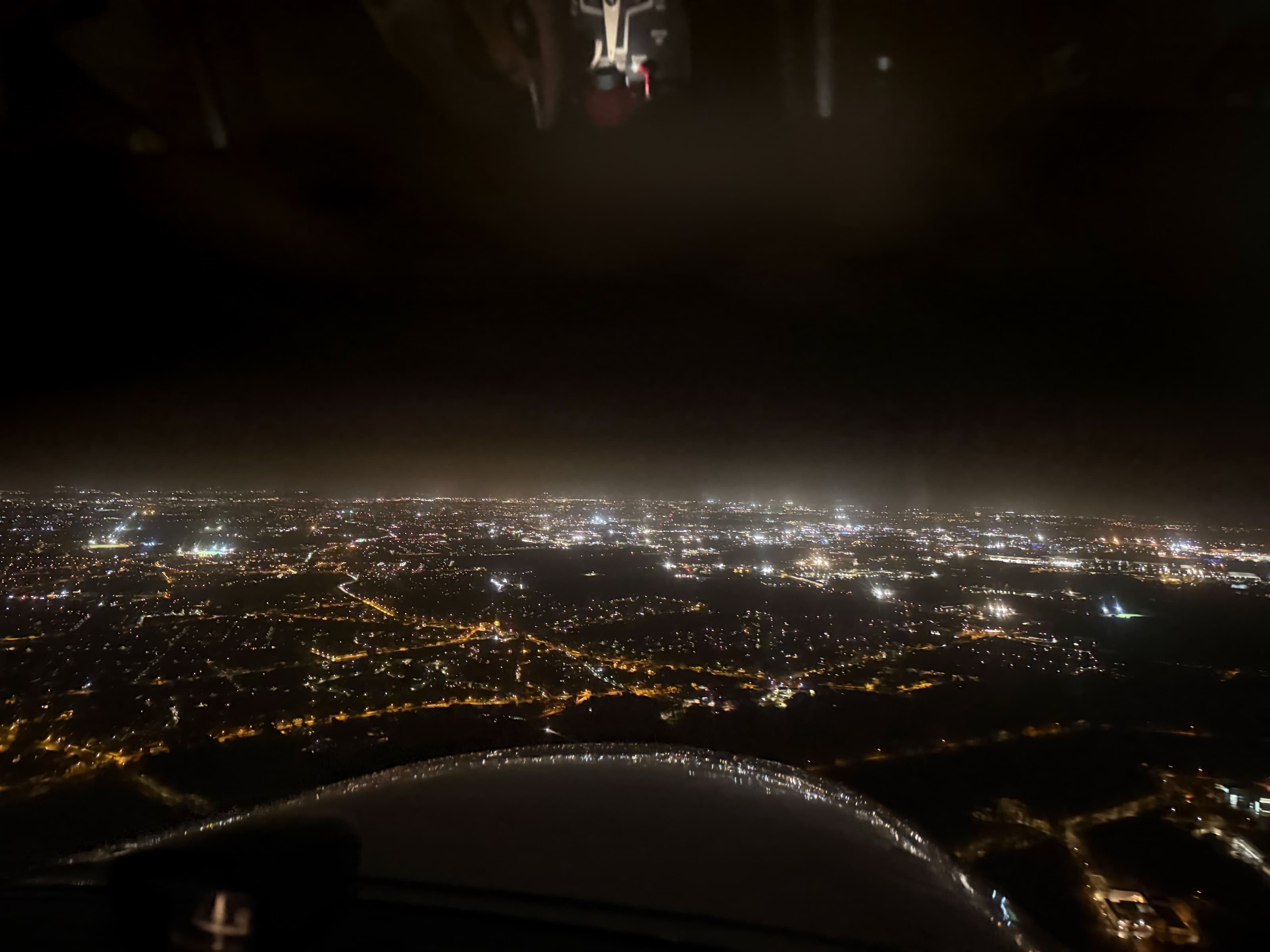 Vue aérienne de nuit depuis un avion du club, lumières de la ville en contrebas