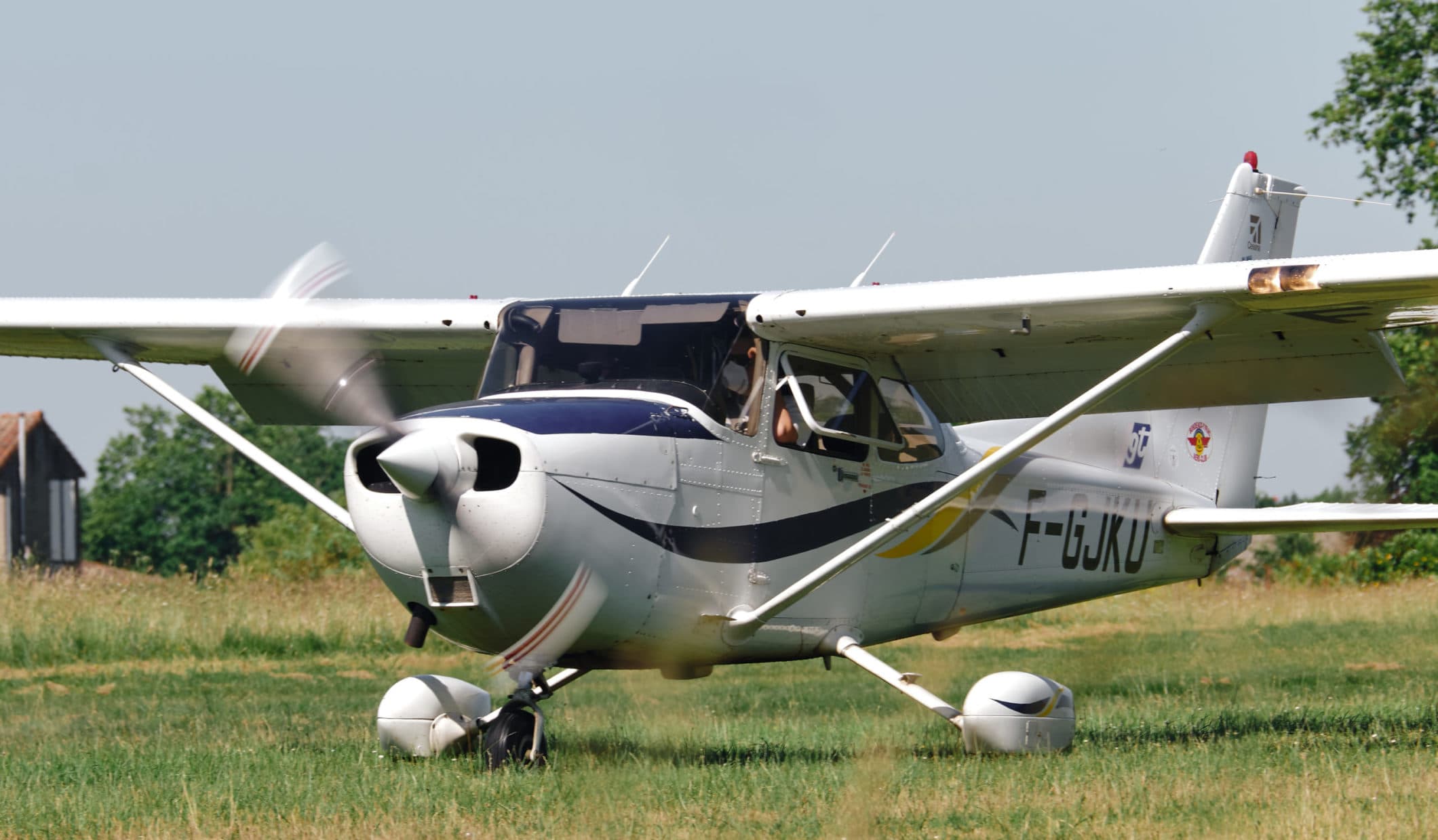 Cessna 172R Skyhawk F-GJKU au sol sur l'herbe, contre-jour