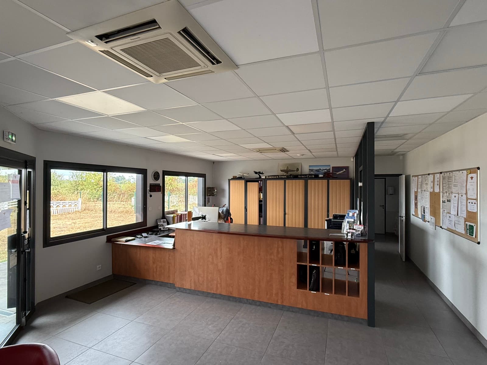 Espace commun du club-house, panneau d'affichage et casiers des membres